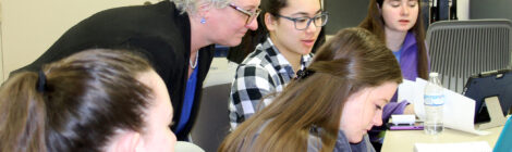 Dean Kim Haverkos, Ph.D., works with Thomas More students in the classroom.