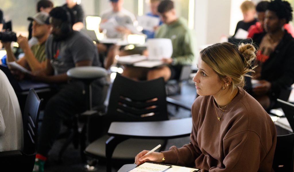 Attentive students in classroom setting taking notes in a lecture setting